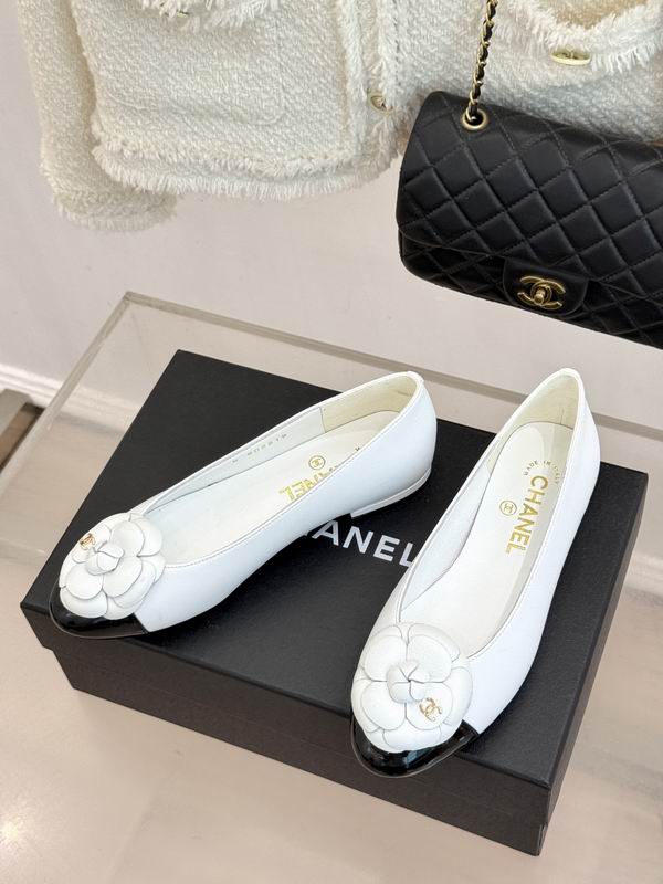 Chanel Camellia ballet flats in white leather with black cap toe, displayed on Chanel branded box