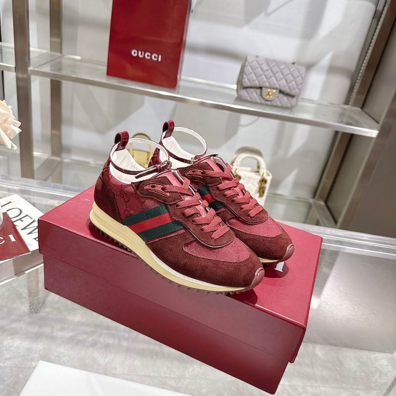 Gucci GG Canvas Runner Sneakers in crimson red with green-red-green Web stripe, displayed on a red shoe box in a luxury retail setting